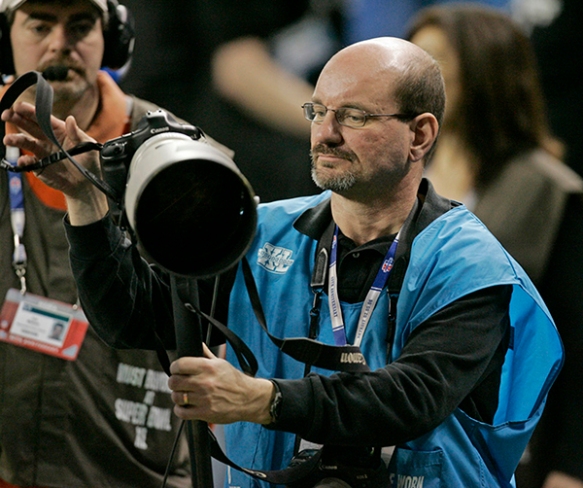 Indianapolis-based photographer Mike Conroy on the field at the start of the NFL Super Bowl XL Feb. 5, 2006 in Detroit, Michigan. (AP Photo/Amy Sancetta)